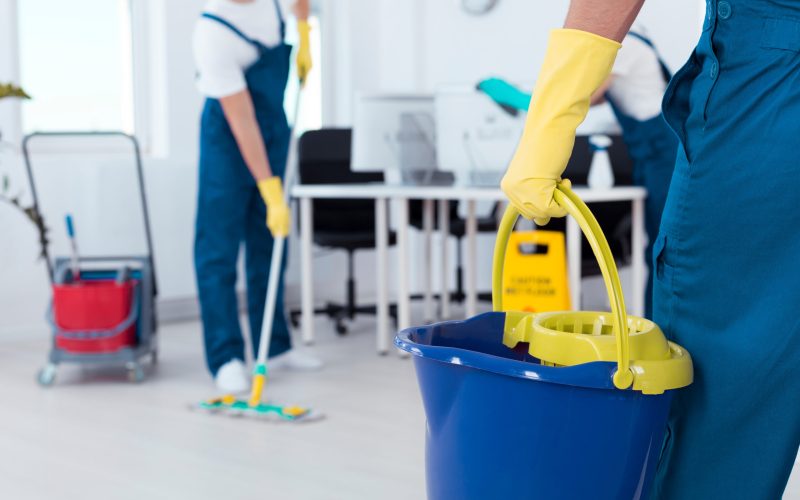 Close up of a man holding a mop bucket